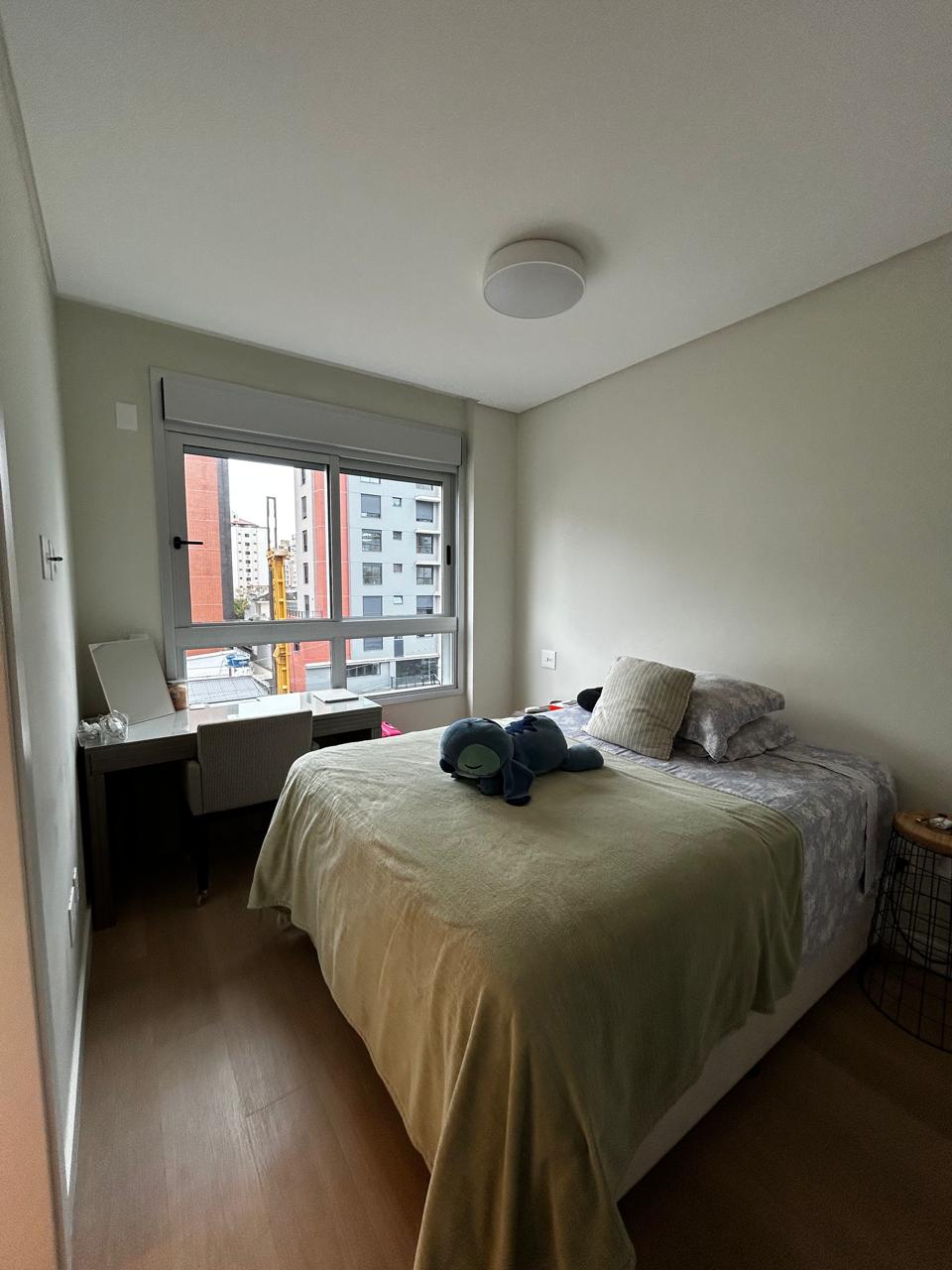 Quarto com cama feita e penteadeira